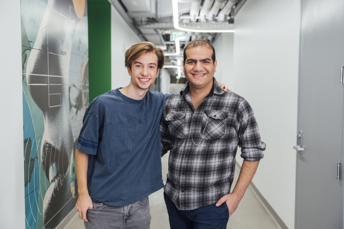 Beckett and Aryan smiling outside of the Quest offices.