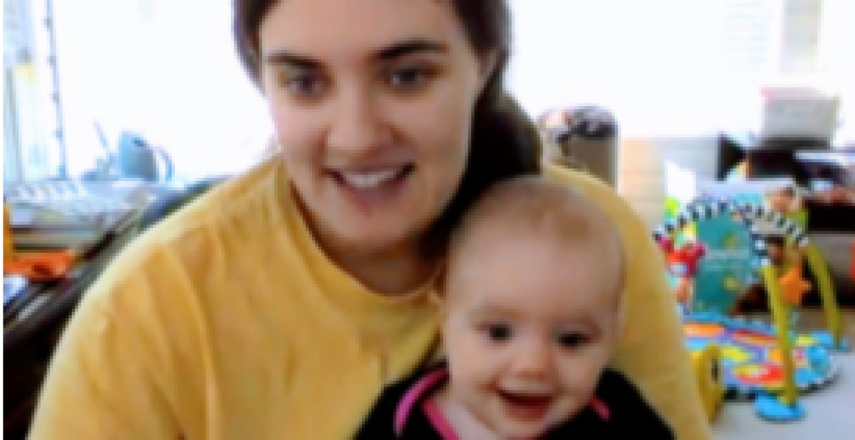woman holding baby, both looking at camera